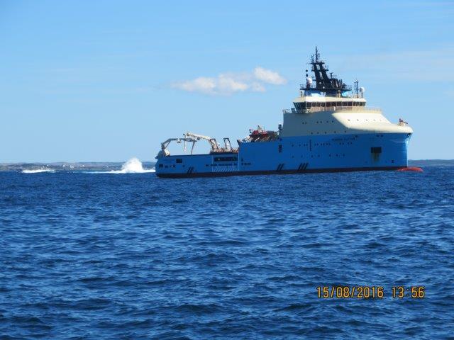 A vessel seen across an expanse of deep blue water